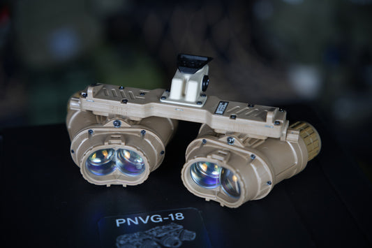 Representative tan ARGUS APNVG PNVG-18 quad-tube night vision device, front angled studio view; tube and mount configuration may vary