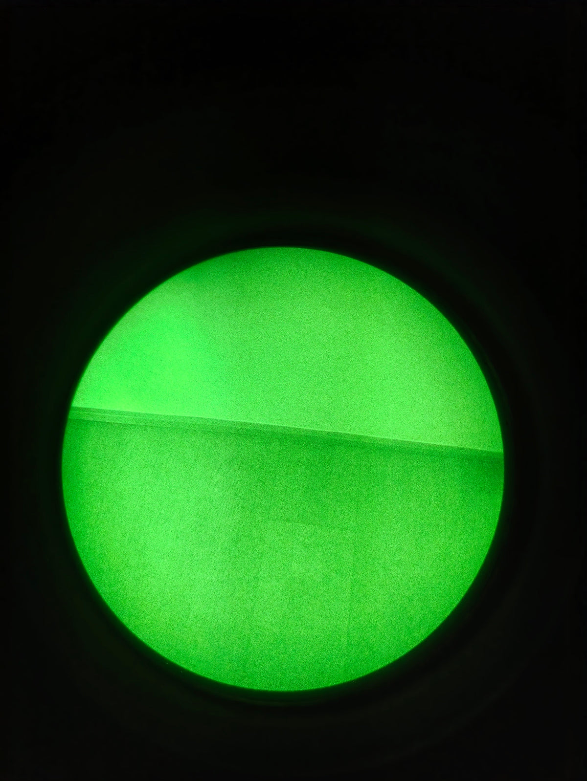 New green-phosphor through-tube photograph of an indoor wall and surface boundary, recorded with the Kaelor Works BNVD-1431. Individual tube appearance varies.